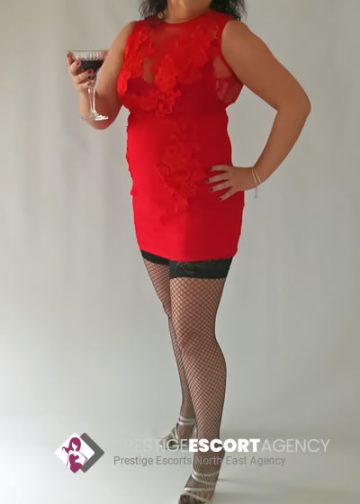 Woman in red dress holding drink, fishnet tights.